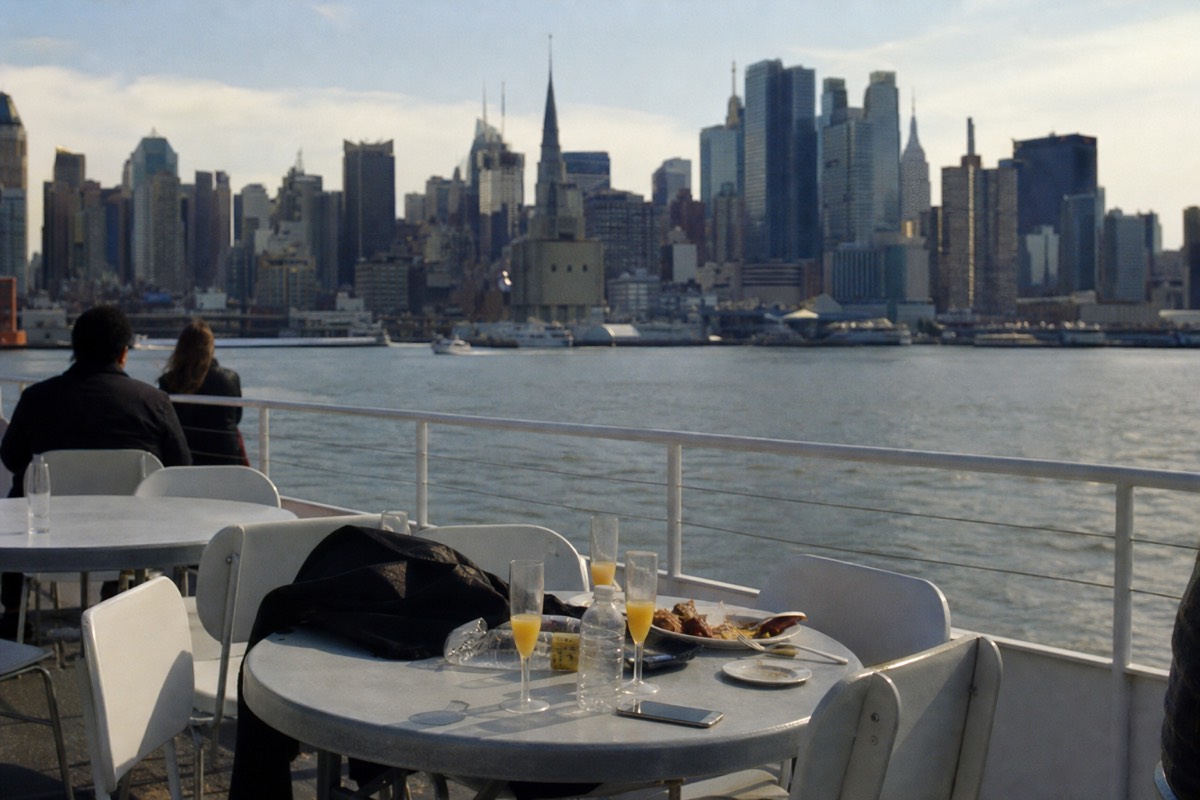 Brunch table with mimosas on the open deck of a Manhattan brunch cruise in daylight