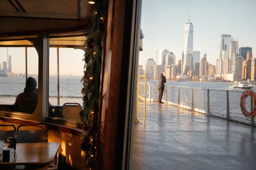 Warm-lit boat interior in winter with a decorated garland along the window frame and mugs on the tables